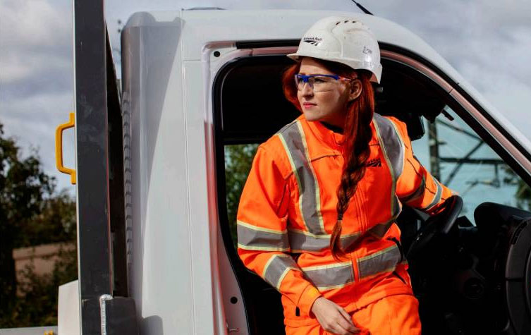 A woman in protective gear exiting a truck