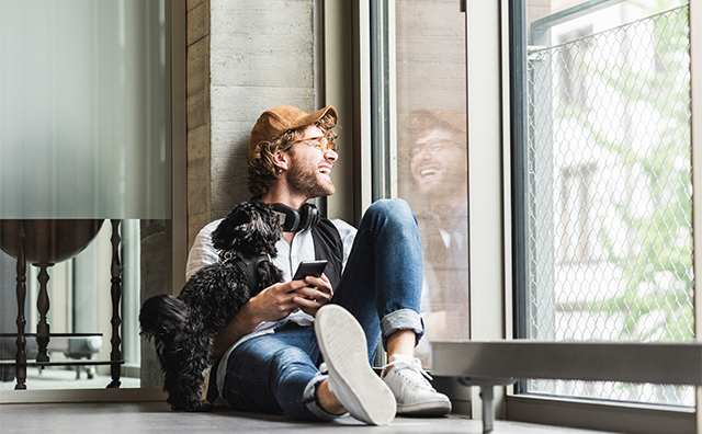Man with dog laughing and looking outside