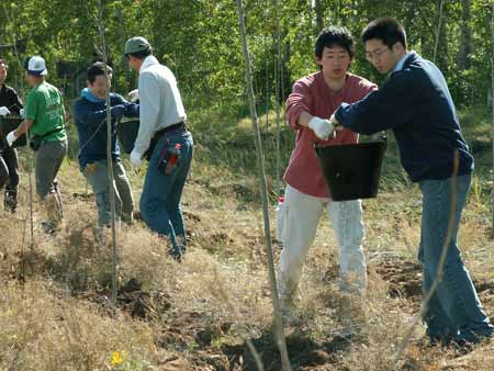 富士通工会的志愿者在给树苗浇水