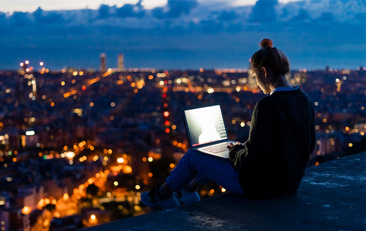 Young woman using a digital laptop at night