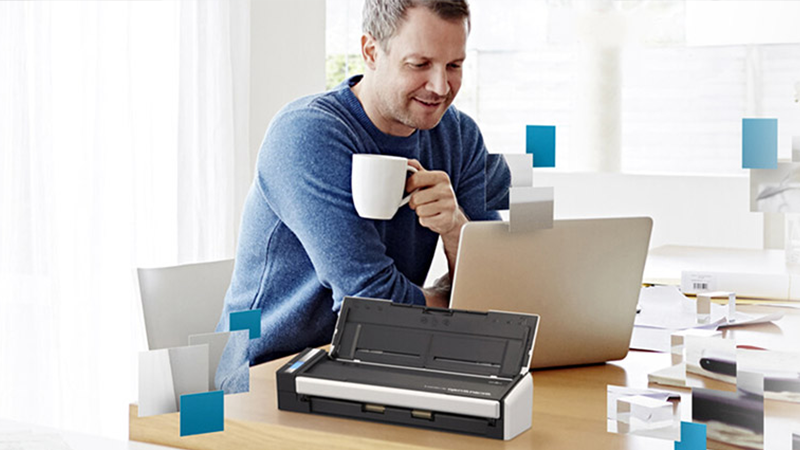 Man drinking coffee at computer - 800x450