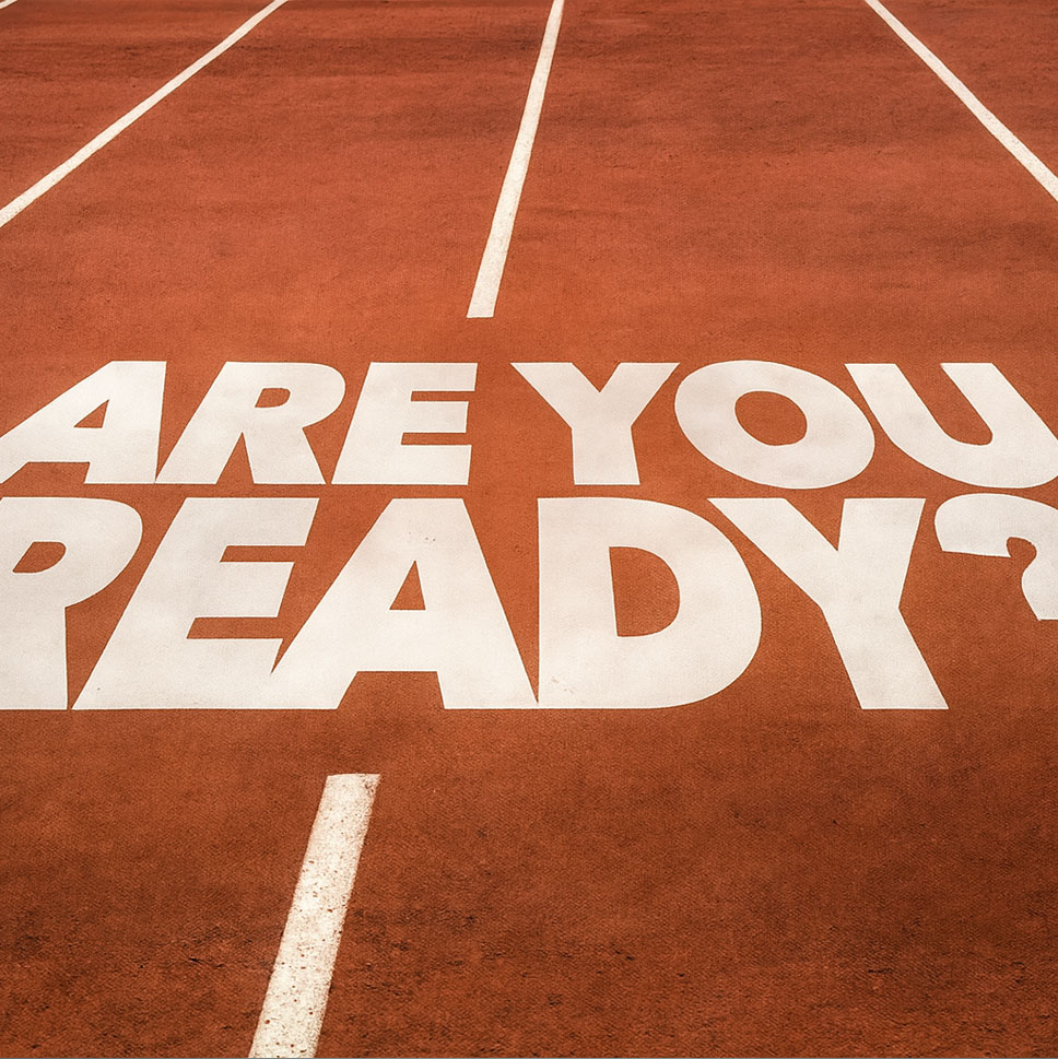 ARE-YOU-READY-painted-in bold-white-letters on-a-red-running track-with-lane-lines