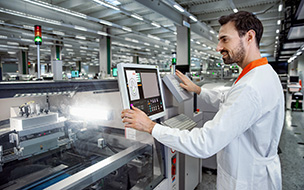 Photo of a person in a laboratory using a PalmSecure scanner to access a computer screen. 