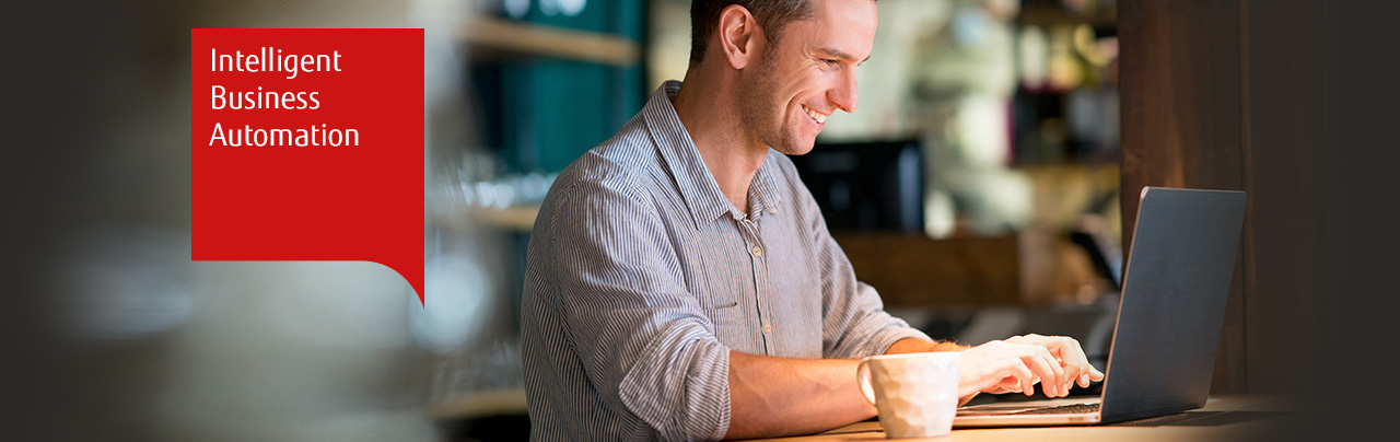 Photo of a smiling man using a laptop