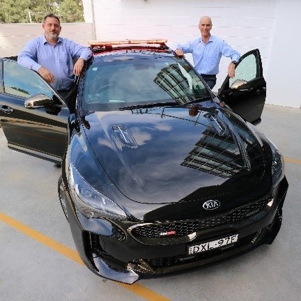 Photo : Principal Architect Ian Hamer gives CEO Mike Foster a demonstration of the police car of the future.