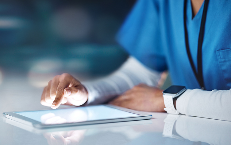A doctor using a tablet computer to review patient records.