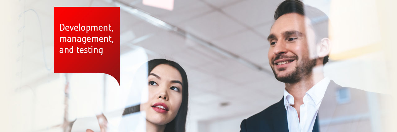 Photo of a man and woman looking at graphs on a glass screen