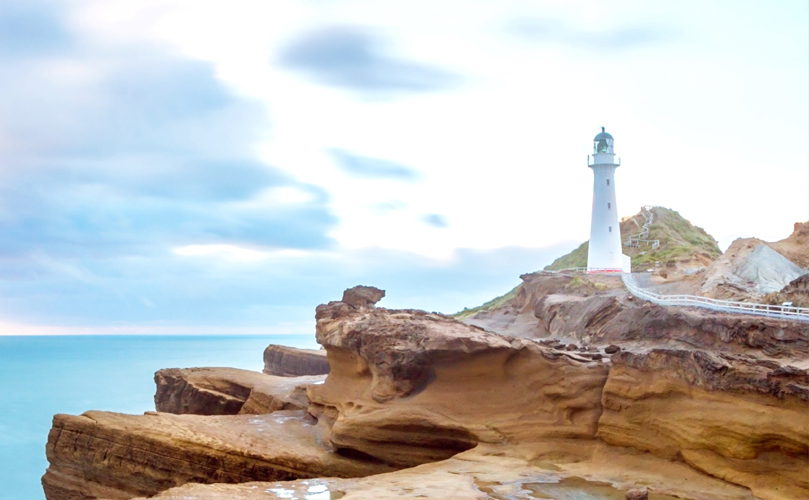 a lighthouse on a cliff by the ocean