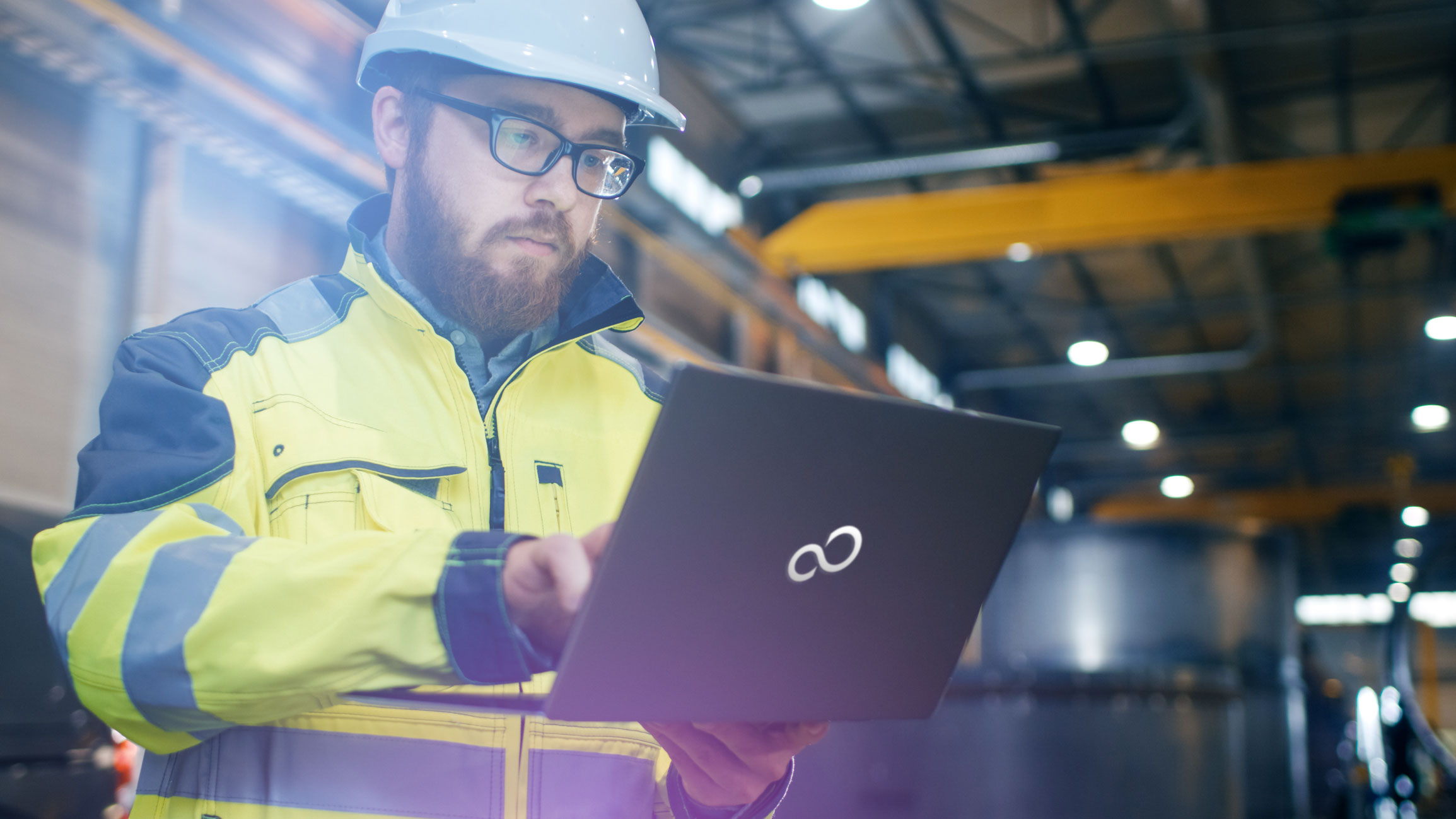 Wharehouse employee finding stock information on a laptop