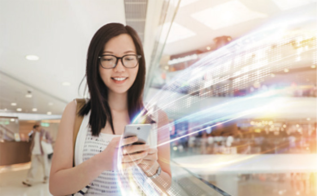 Photo of a woman in a shopping center, interacting with content on her phone