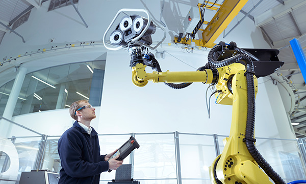 Person operating a robot in a digital manufacturing plant