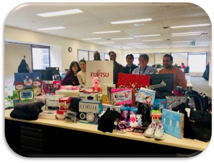 Photo of donated gifts with some of the Fujitsu US employees