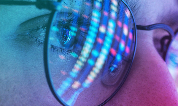 Reflection of a digital screen in reading glasses, symbolizing the future of information technology.