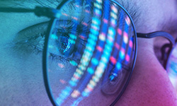 Reflection of a digital screen in reading glasses, symbolizing the future of information technology.