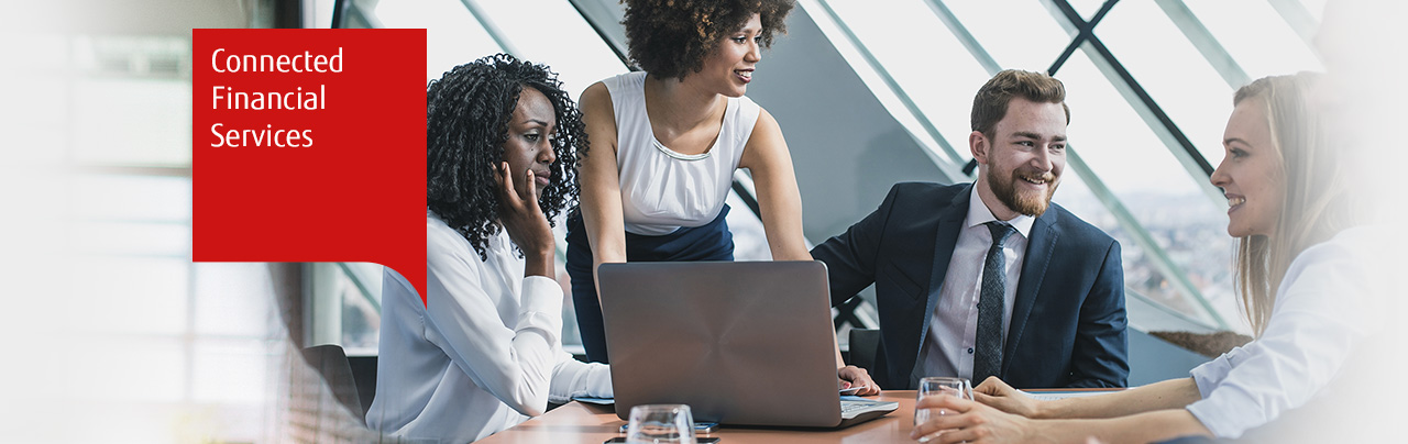 Photo of four business people working round a laptop