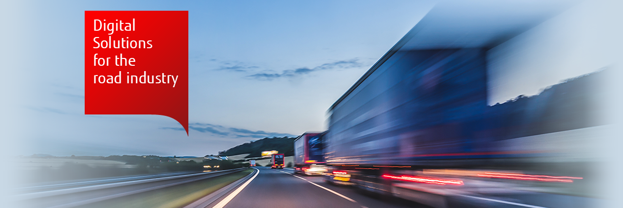 Motion-blurred photo of a line of lorries on a road at dusk