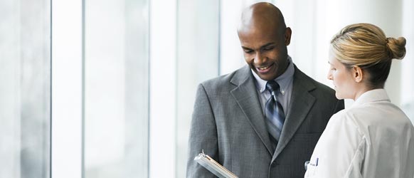 Picture of a man and a woman talking while looking at a clipboard