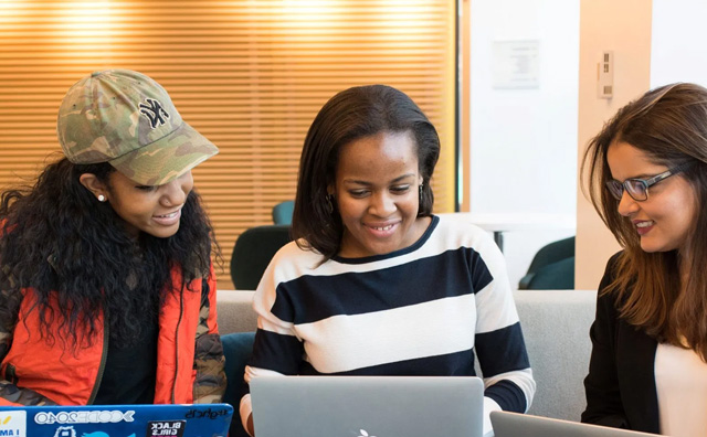 Three women looking at laptops