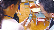 特別支援学校の教師にアプリの操作を説明している写真