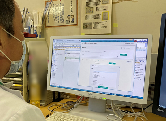 図1. 診療現場で「今日の問診票」によって作られた電子カルテの下書きを確認する医師