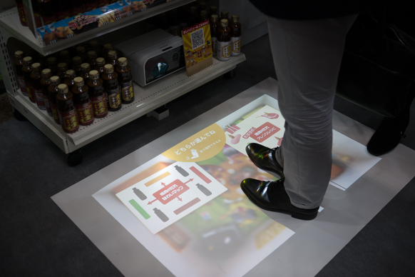 共創から生まれた焼肉のタレ「未来の棚」は、足を使って映像を操作