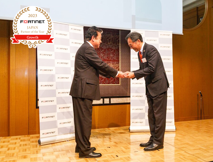 フォーティネットジャパン 社長執行役員 与沢 和紀 様（左）より富士通エフサス 取締役常務 竹田 錠一 へトロフィーが授与されました。
