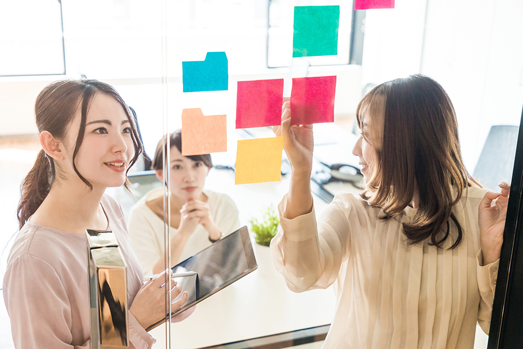 ボードを使って会話する3人の女性