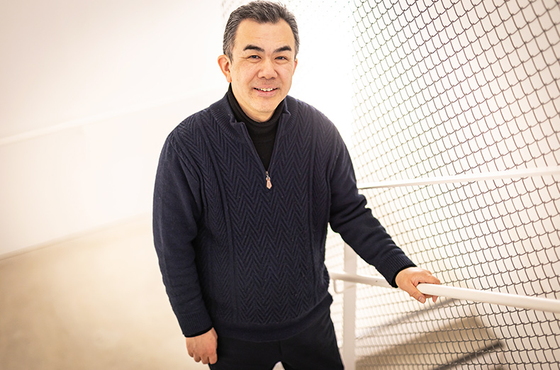 階段に立つ越塚 登氏