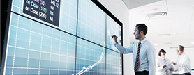 Man standing in front of a large screen pointing at the results being displayed