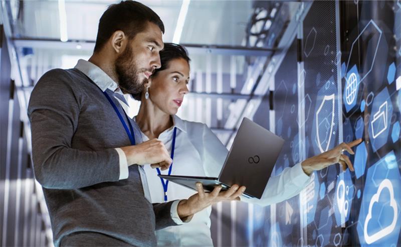 woman and men holding fujitsu laptop and touching the screen 