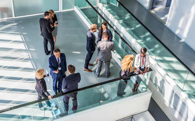 People stood in an office talking to each other - photo taken from above.