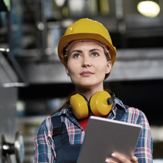 Woman wearing safety had and headphones - Health and Safety