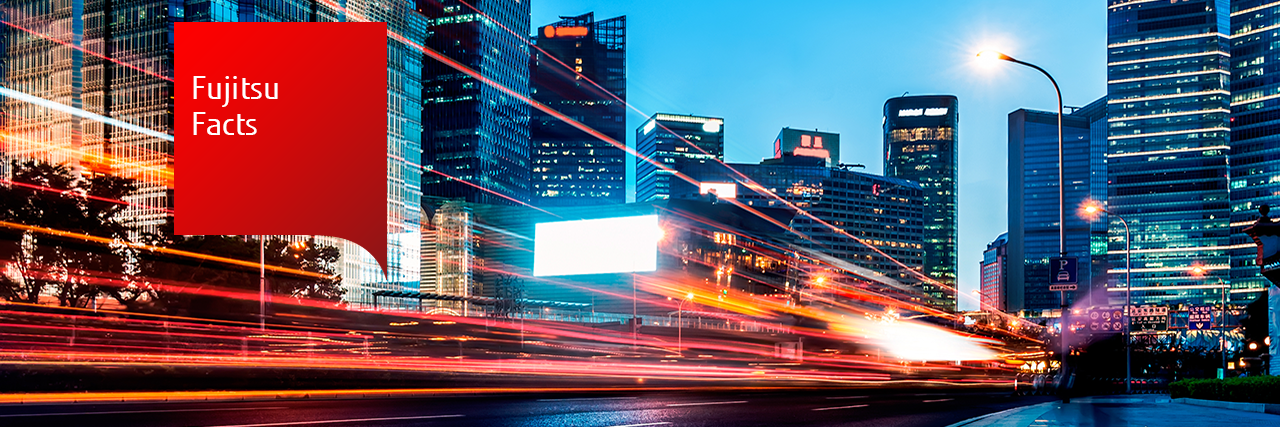 Fujitsu facts: photo of motion blur lights from traffic, with a modern city in the background. 