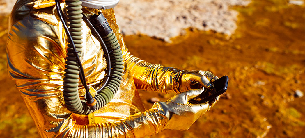 Spaceman in gold space suit using phone
