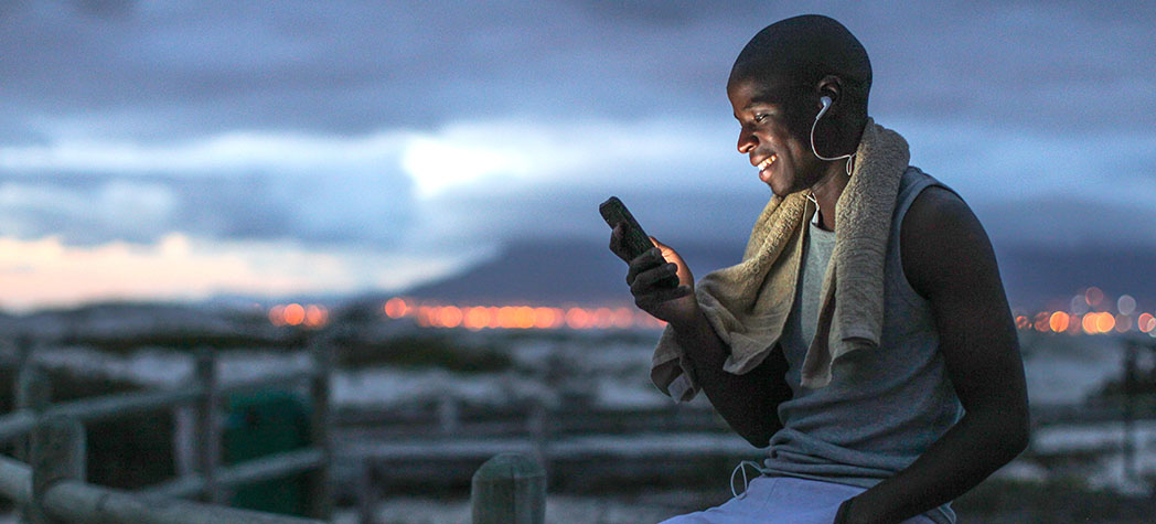 Person using phone in front of cloudy sky