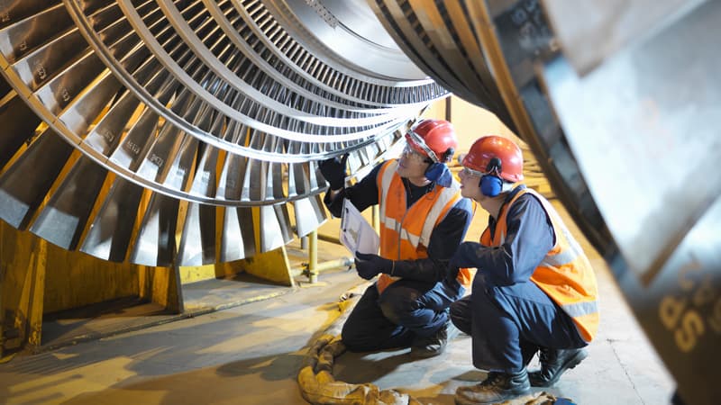 Two man under a turbine